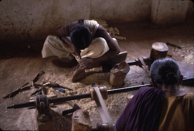 women working on wood lathes in India